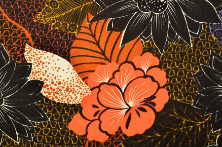 Orange floral pattern on fabric. Colorful abstract flower print as background.の写真素材