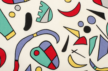 Different colorful shapes on white fabric. Abstract geometric shapes print as background.