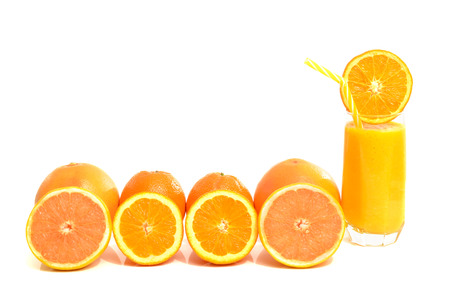 Grapefruit and oranges in a row with a glass of fresh orange juice. Half slices of citrus fruits isolated on white.の写真素材