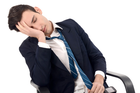 Young business man sleeping in the chair. Tiered employee sleeping on the job.
