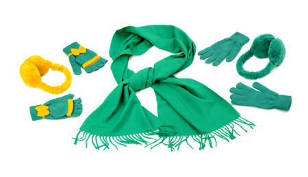 Styling a green scarf with different accessories. Green fringe winter scarf, gloves and earmuffs isolated on white background.の写真素材