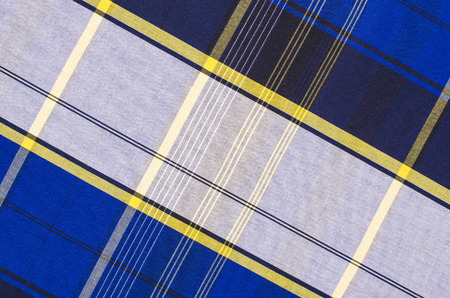 Scottish tartan pattern. Blue and white with yellow plaid print as background. Lines and square...