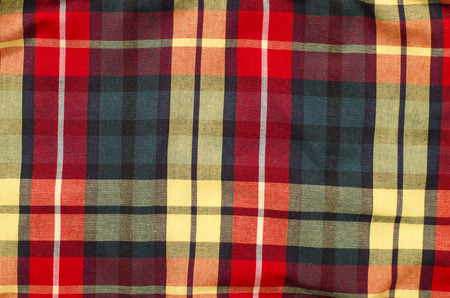 Scottish tartan pattern. Red and purple plaid print as background. Colored lines and square pattern....