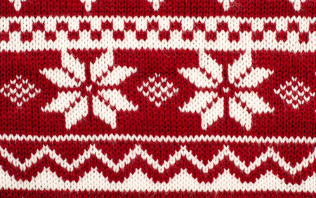 Close up on knit woolen texture. Winter snowflakes shapes pattern background.の写真素材