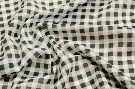 Close up on crumpled checkered tablecloth fabric. Green and white tartan square pattern as background.の写真素材