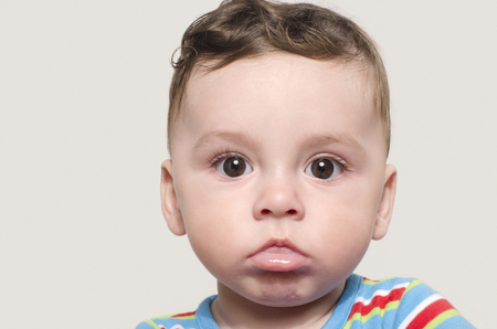 Portrait of a cute baby boy looking at camera. Adorable six month old child.