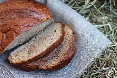 Brown fresh sliced bread and flax textile on hay
