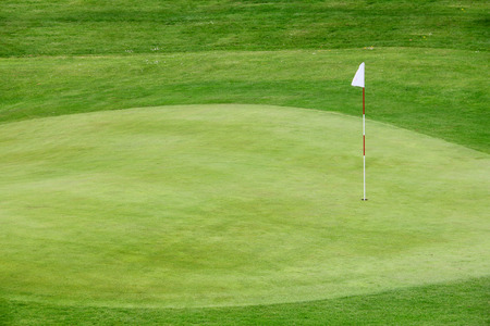 Golf flag on the green grass field close up