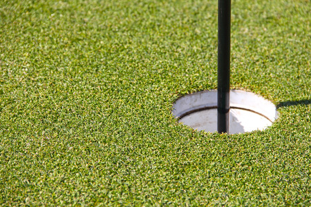 Golf hole and flag with the green grass