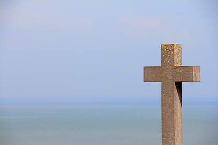 Old stone Grave gross over sea and sky backgroundの写真素材