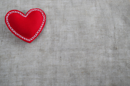 Red Valentines day decorative fabric heart on gray textile background with copy spaceの写真素材