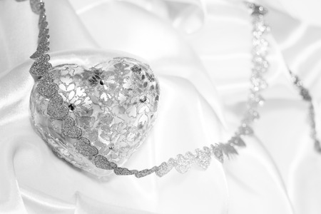 Silver glass heart Valentine day gift on silk backgroundの写真素材
