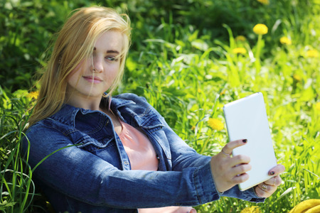 Young beautiful woman taking selfie outdoors in spring parkの写真素材