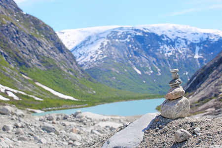 Stack of rocks with mountain and fjord view in Jostedalsbreen National Park, Briksdalen valley,...