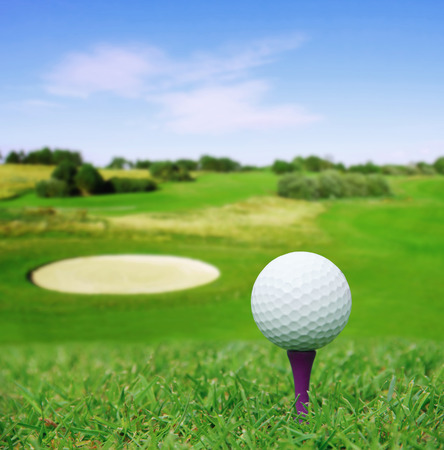 Golf ball on course with beautiful blurry landscape on backgroundの写真素材