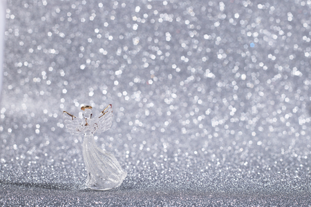 Christmas angel on shiny glitter silver background with copy spaceの写真素材