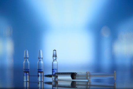 Medical syringe and vials on table in hospital