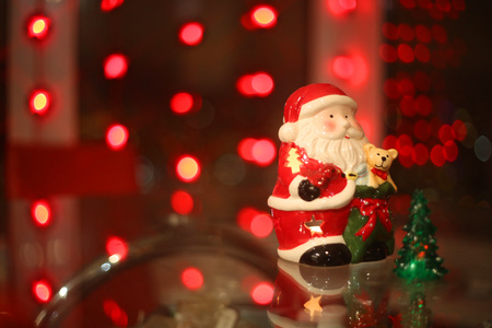 Santa Claus toy and fir tree on red bokeh backgroundの写真素材