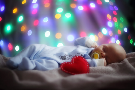 Love newborn baby Valentines day concept woth gearts and bokeh lightsの写真素材
