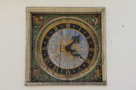 Ancient outdoor clock on white wall in old Tallinn, Estonia
