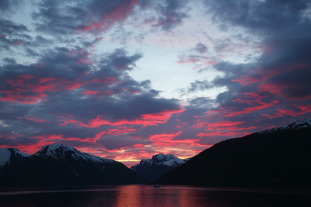 Sunset over water of fjord and mountains in Vangsnes, Norwayの写真素材