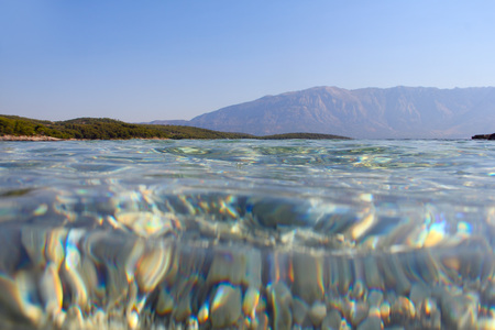 Underwater sea view background of transparent clear water, sea bottom and surface from belowの写真素材