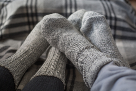 Feet of couple in woollen socks on checkered blanket, home comfort and love conceptの写真素材