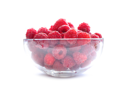 Big Pile of Fresh Raspberries in transparent bowl isolated on the white background