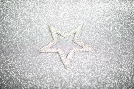 Christmas holiday composition of festive decor star on silver glitter bokeh background