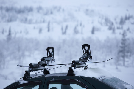 Car with ski rack on top. Winter sports design element , travel by car for skiing and snowboarding carrying own snowboardの写真素材