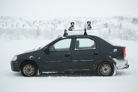 Car with ski rack on top. Winter sports design element , travel by car for skiing and snowboarding carrying own snowboardの写真素材