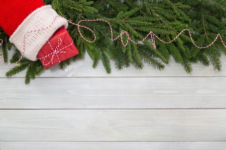Christmas new year flat lay decor of fir branches, sock and gift on white toned natural wooden plank background texture provence style with copy space for textの写真素材