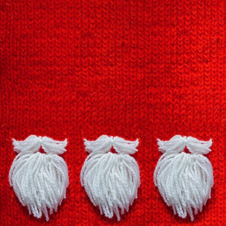 Santa's beard on red knitted woolen background with copy space for text Christmas concept