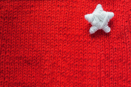 Handmade Christmas Star on red knitted woolen background with copy space for textの写真素材