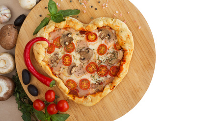 Pizza heart shaped with ham tomatoes and mushrooms on wooden background . Concept of romantic love for Valentines Day . Love foodの写真素材