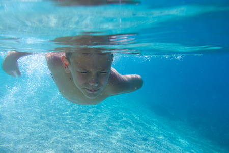 Boy diving on a breath hold swimming under water viewの写真素材