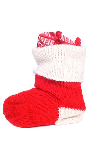 Stuffed Christmas stocking red and white woolen sock with gifts inside isolated on white backgroundの写真素材