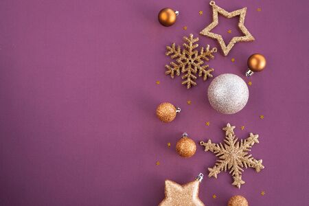 Christmas Border frame of golden glitter ornaments on purple paper background with copy space for textの写真素材