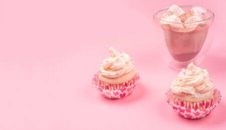 Valentine day love cupcake decorated with cream and hot chocolate on pink background with copy space for textの写真素材