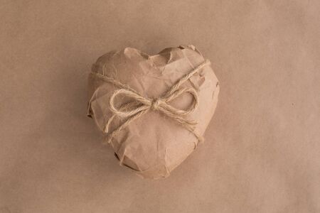 Heart in brown Wrapping Paper tied with rope bow on background Valentine day surprise conceptの写真素材
