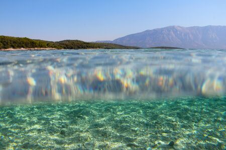 Underwater sea view background of transparent clear water, sea bottom and surface from below