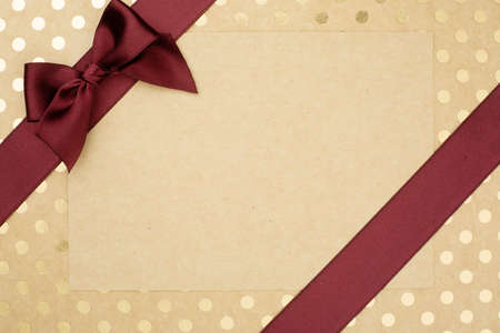 Abstract holiday gift background of craft paper with golden pin-up dots dotted with silk satin...