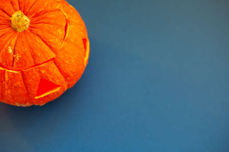 Halloween pumpkin on blue background unusual composition background with copy space for textの写真素材