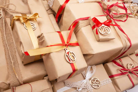 Similar craft paper surprise advent gifts with wooden numbers and red and white decorative ribbon...