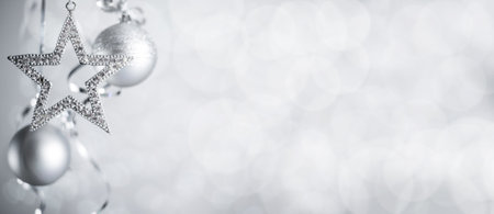 Silver Christmas new year balls and star with curly streamer ribbon bow over glittering bokeh lights background with copy space for textの写真素材