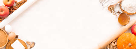 Autumn baking background border frame design with copy space for text. Cooking ingredients pumpkin, apples, wheat, honey butter flour nuts, toning, bright orange colorsの写真素材