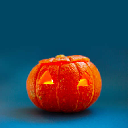 Halloween pumpkin on blue background unusual composition background with copy space for textの写真素材