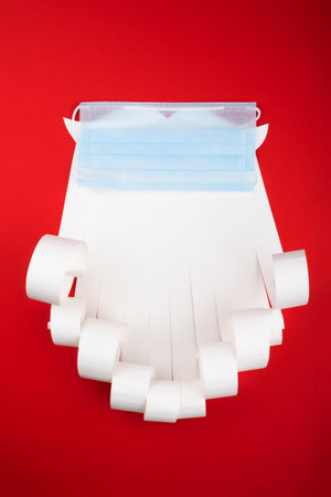 Santa Claus beard with face mask on red background, creative minimal concept of Christmas and New Year safe celebrationの写真素材