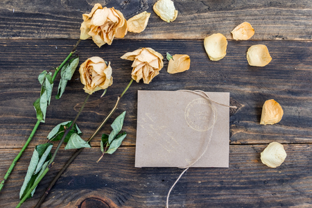 A bouquet of dried flowers on a wooden background. Postcard, background with place for inscription. Dry roses as a decoration.の写真素材