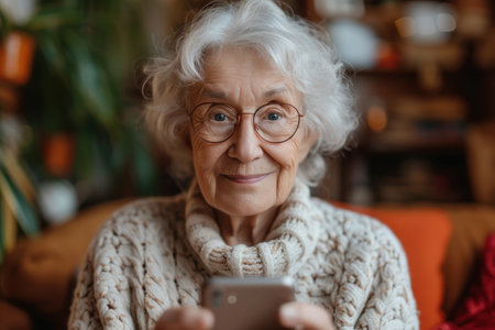 Elderly Woman Holding Smart Phone in Handsの素材